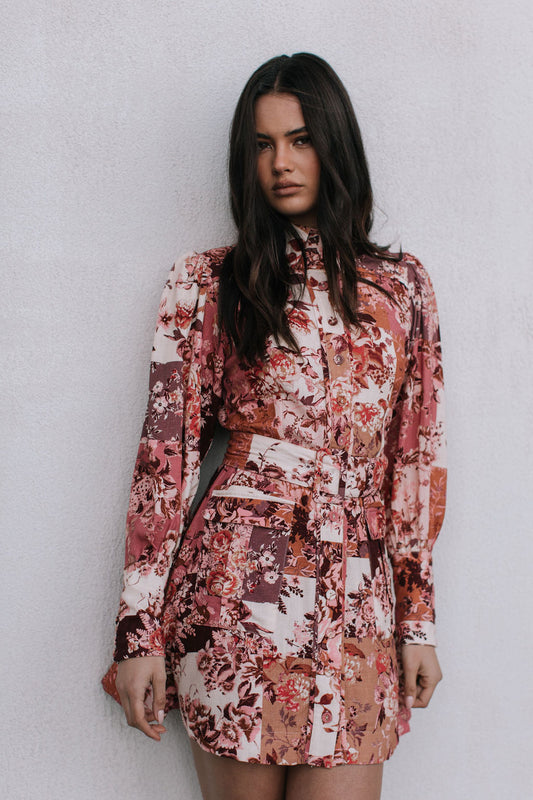 Woman wearing a floral dress against a plain background