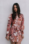Woman wearing a floral dress against a plain background