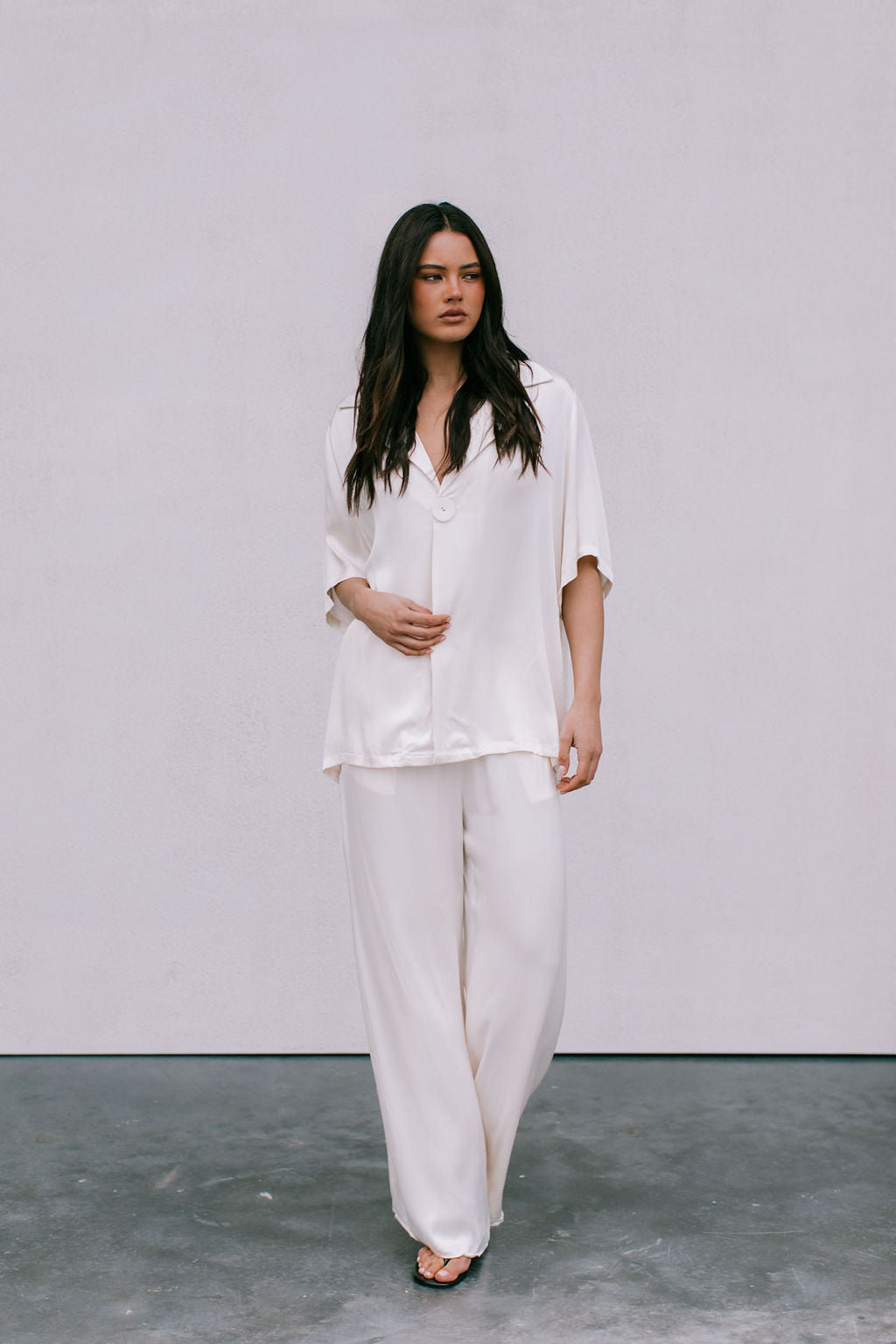 Woman wearing a white outfit against a plain background