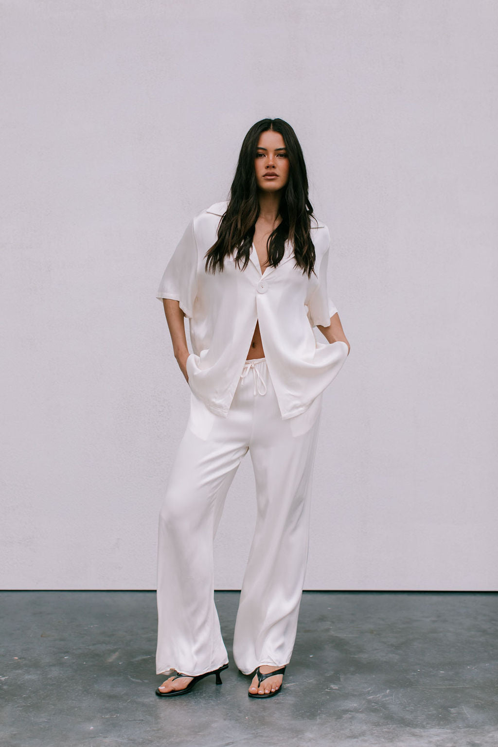 Woman wearing a white outfit against a plain background