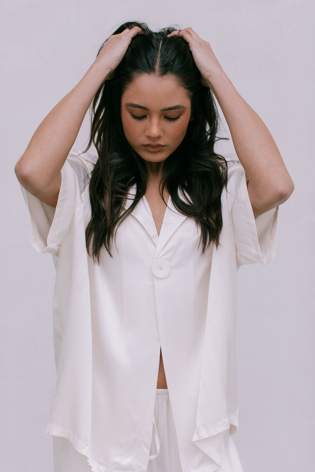 Woman wearing a white outfit against a plain background