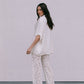Woman wearing a white outfit with a plain background