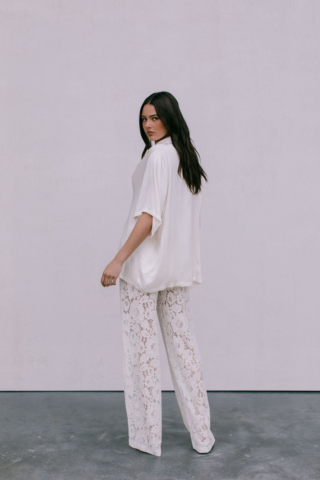 Woman wearing a white outfit with a plain background