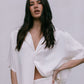 Woman wearing a white outfit against a plain background