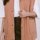 Person wearing a tan vest over a white shirt and brown skirt on a white background