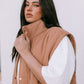 Woman wearing a brown vest over a white shirt against a white background