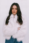 Woman wearing a white fluffy coat against a light background